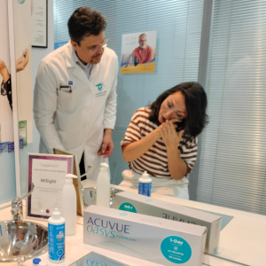 Miguel Barranco Martos óptico optometrista enseñando a clienta a usar lentillas en óptica Opticaudio Gamonal