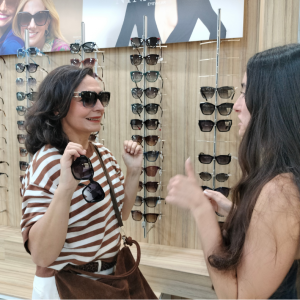 Clienta probándose gafas de sol en Óptica Opticaudio Gamonal
