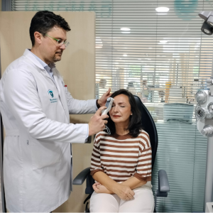 Miguel Barrando Martos midiendo presión intraocular de la paciente con un tonómetro portátil de rebote en Óptica Opticaudio Gamonal