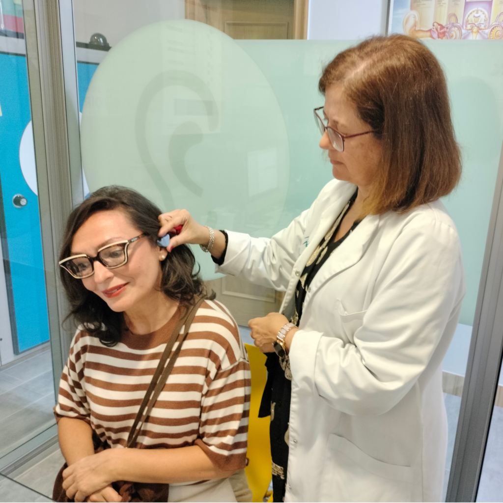 Marta Serrano audióloga realizando molde en oído de clienta Opticaudio Gamonal Burgos